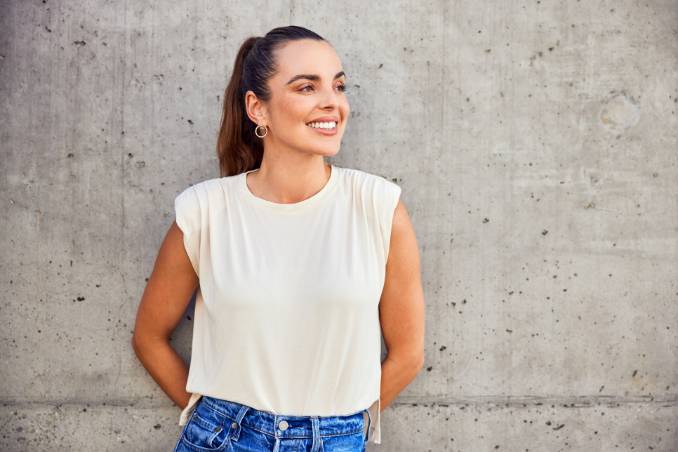 Woman in white shirt with hands behind back
